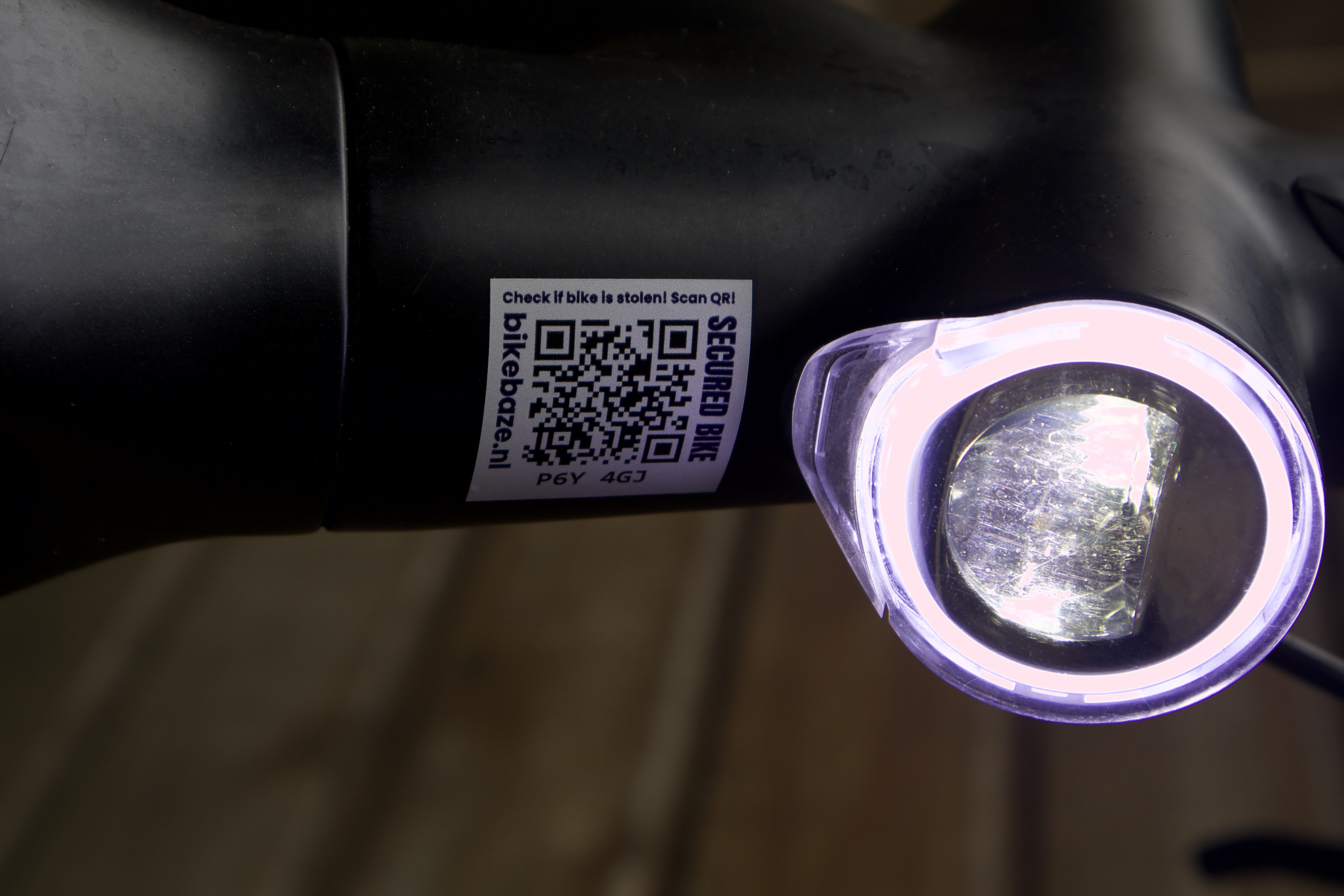 Grijze BIKEBAZE SafeTag op een fietsframe, close-up